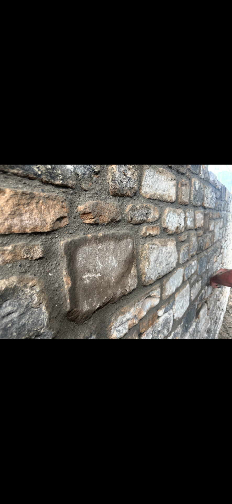 Close-up detail of natural stone wall coursing and fresh mortar joints.